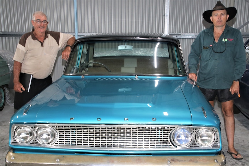 Ron Blundell and his son Paul standing beside a 1960's blue Ford Falcon