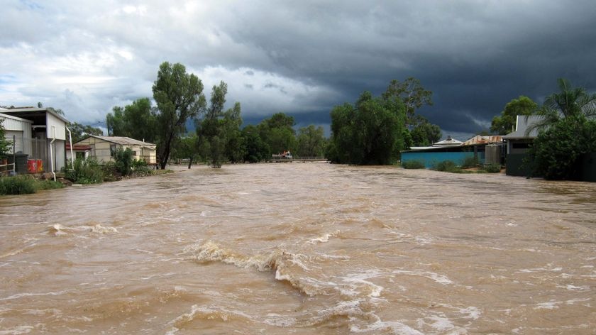 Floodwaters surge down a street in the southern Qld town of Charleville