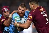 Josh Dugan of the Blues is tackled by Johnathan Thurston and Greg Inglis