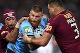 Josh Dugan of the Blues is tackled by Johnathan Thurston and Greg Inglis