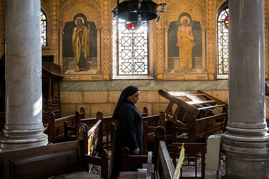 A nun walks through the site of the bombing on December 11, 2016 in Cairo, Egypt