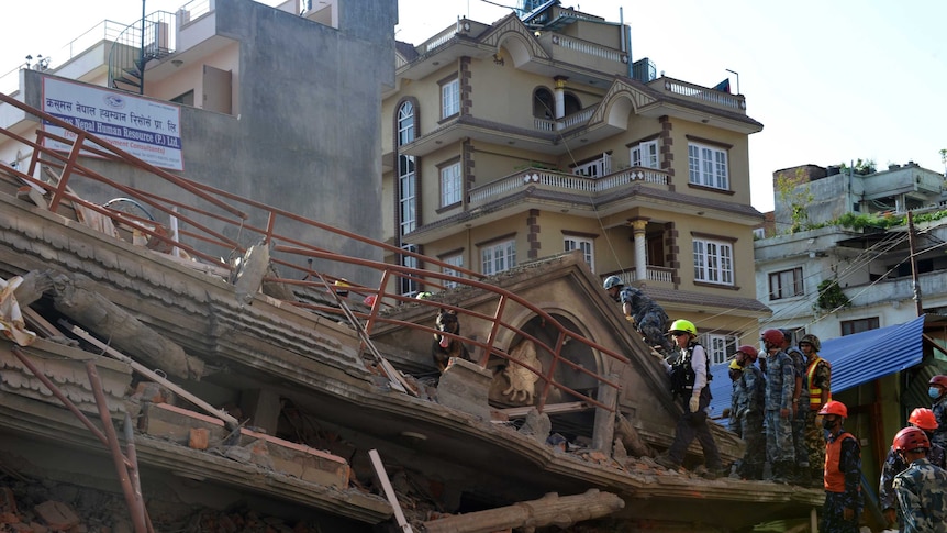 Rescue team officials search for survivors at a collapsed building in Kathmandu