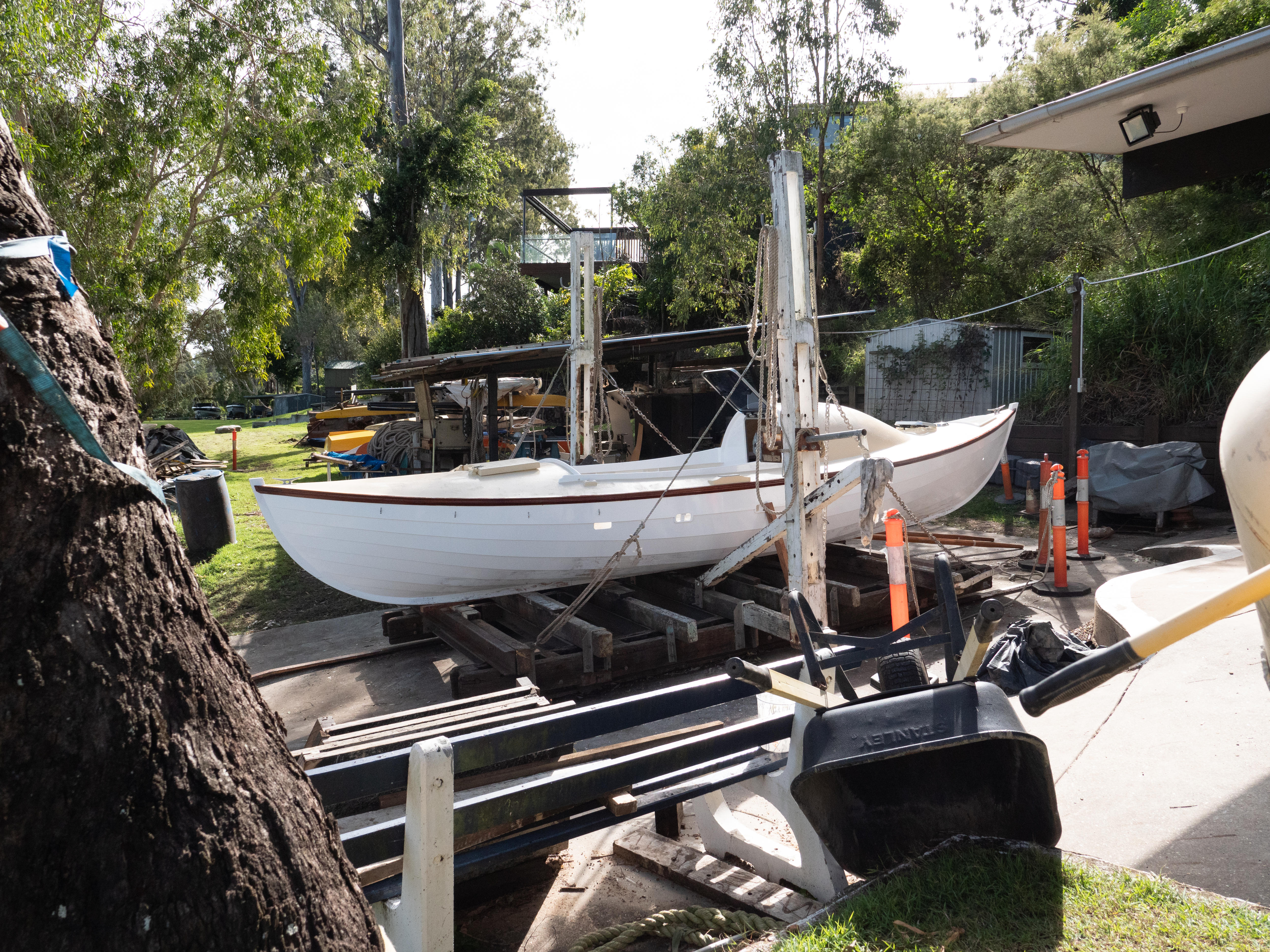 A white rowboat sits atop planks of wood at the Carrington Boat Club in Brisabne