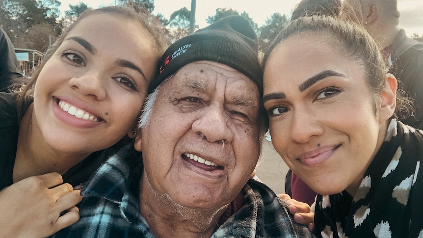 Tahnee is smiling on the right with her grandfather in the middle and her young cousin Natasha on the left