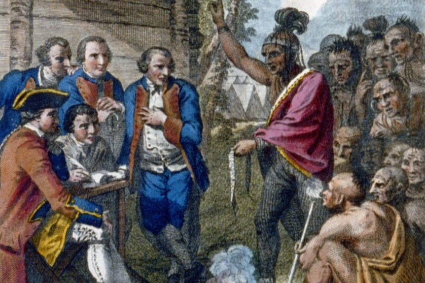 A Native American, surrounded by his people, speaks to Colonel Bouquet and British troops at a council fire in October 1764.