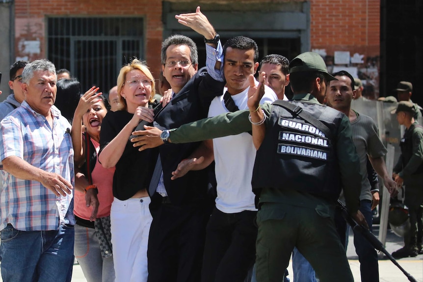 Luisa Ortega Diaz and her supporters are barred entry to their offices by security forces, who are blocking their path.