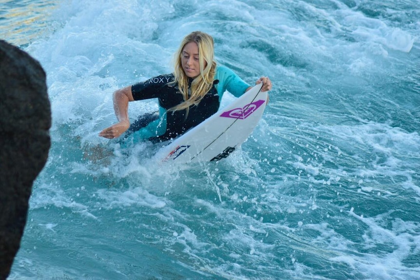 Alyssa Lock on her surf board in the water.