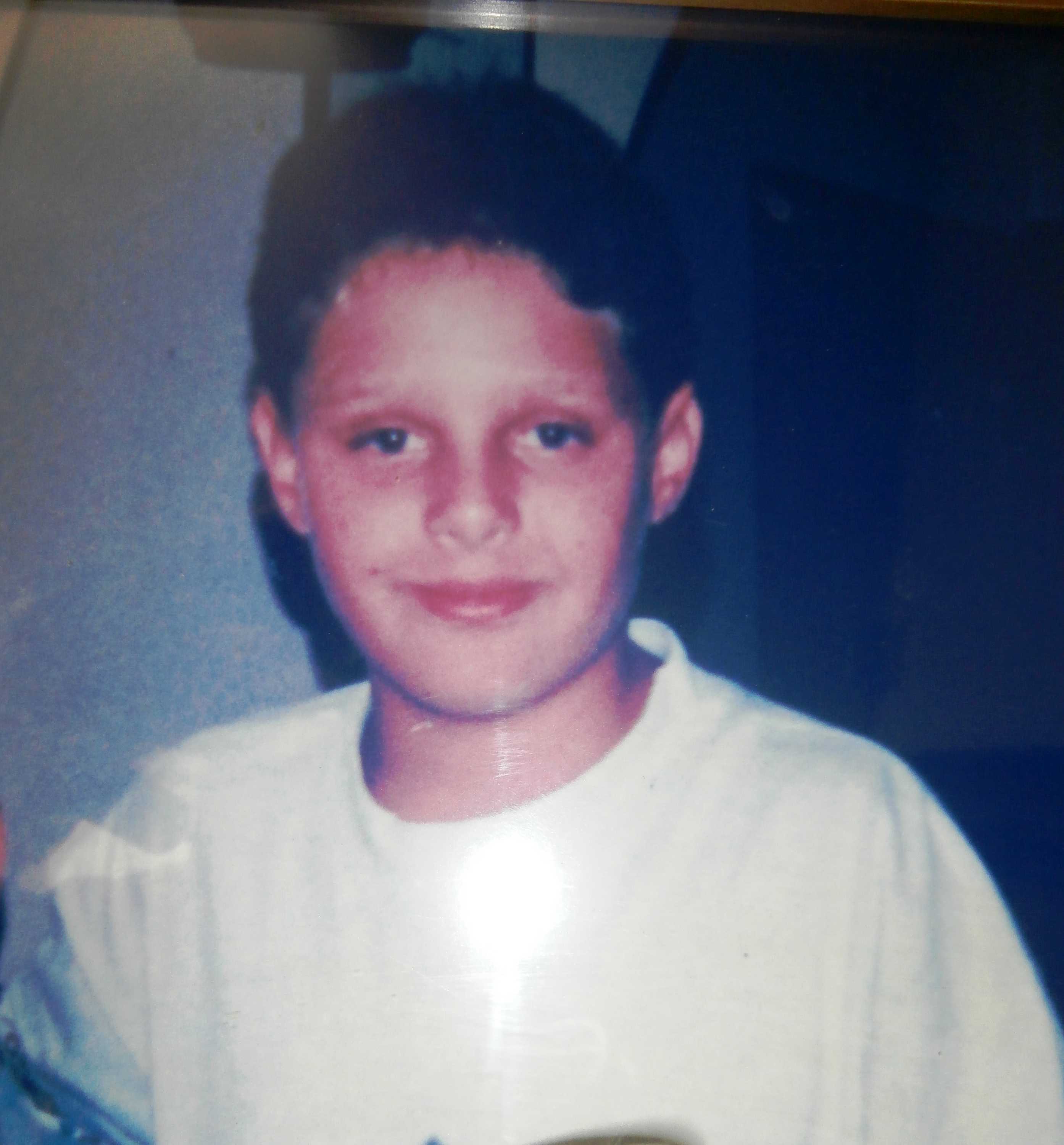 Uma fotografia de um adolescente com uma camiseta branca.