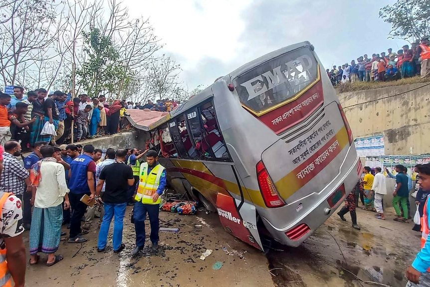 Back view of bus accident on South Asian highway with people standing around