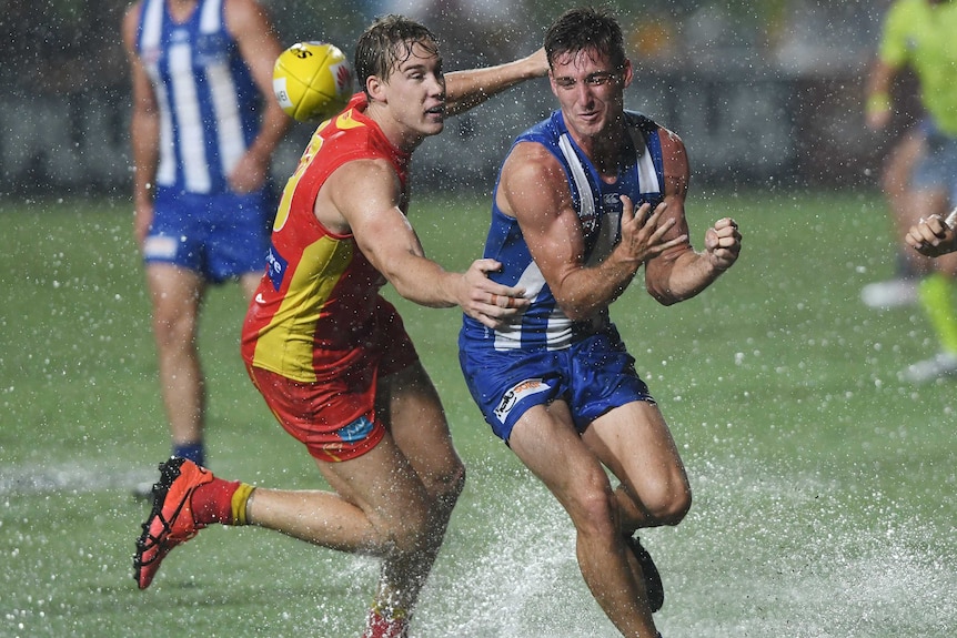 Kangaroos' Jarrad Waite (R) and the Suns' Tom Lynch contest the ball in the wet in Cairns.