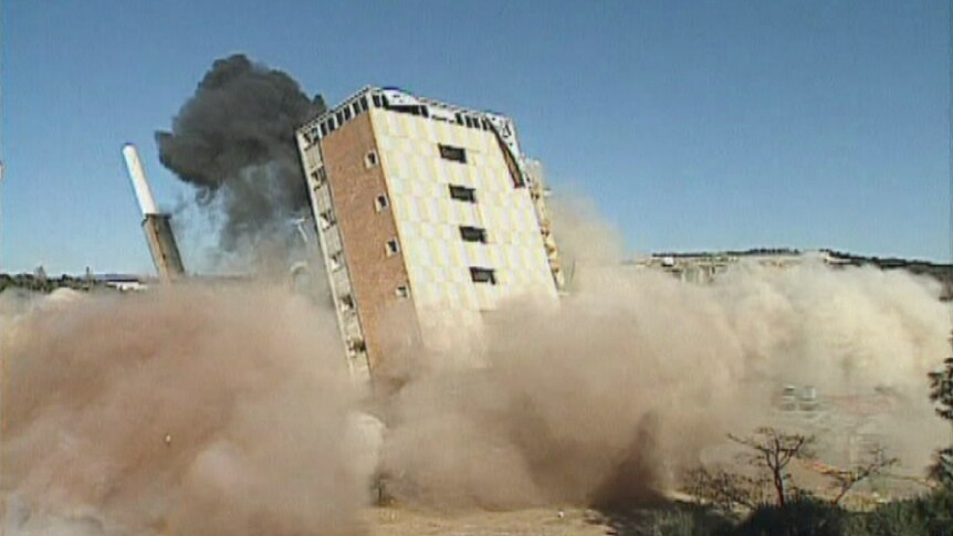 Image showing the Old Canberra Hospital falling after implosion charges for demolition.