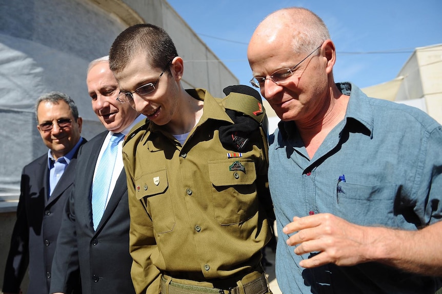 Freed Israeli soldier Gilad Shalit walks with his father, Ehud Barak and Benjamin Netanyahu (Getty Images/Israeli Defence Force)