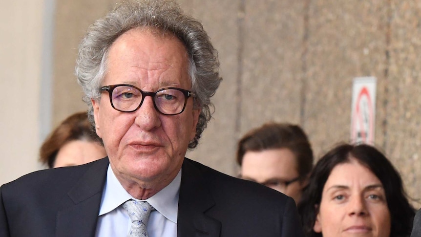 Geoffrey Rush arriving in court on Thursday, flanked by some of his legal team