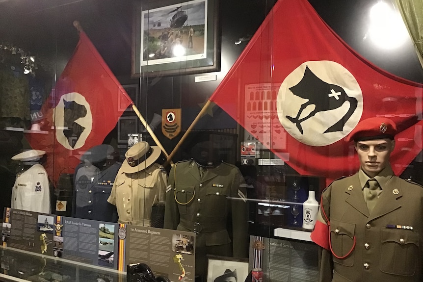 war flags and uniforms on display