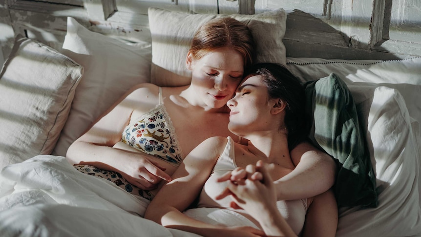 Two women lying in bed hugged each other for a story about when you and your partner have incompatible sex drives.