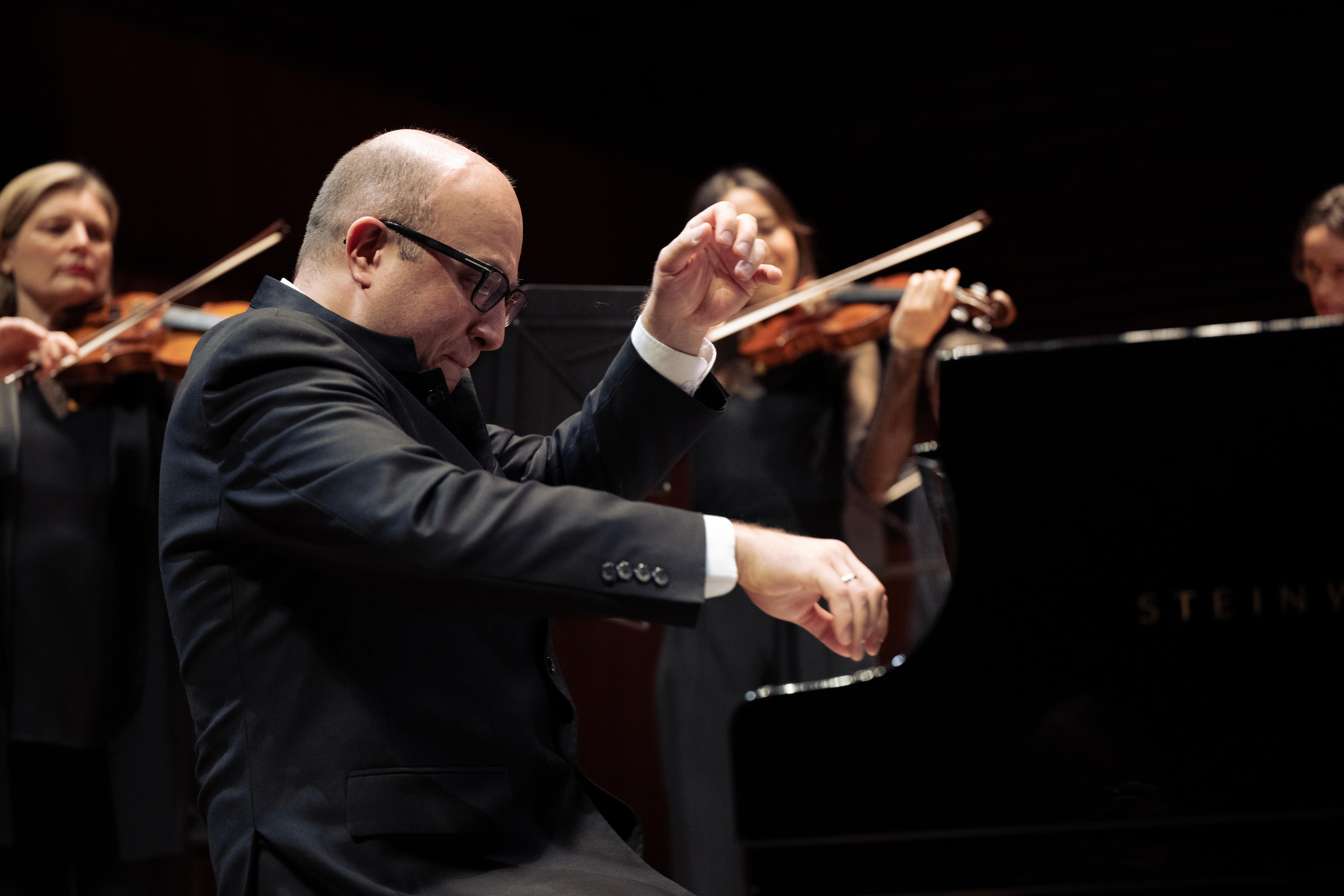 A close up picture of Gavrylyuk's head and hands. Most of the picture is very dark apart from his hands and face. 