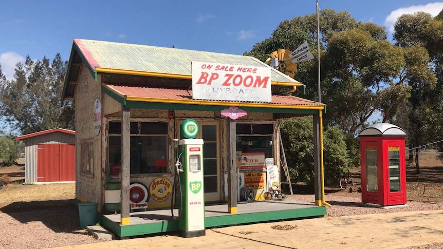 The store front of the 1930s petrol station Mick restored, complete with old pump and red phone box outside.