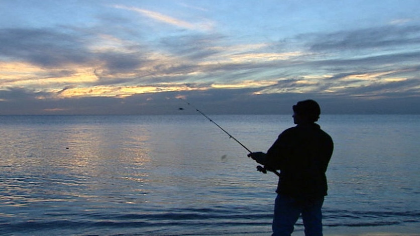 fisherman silhouette off rocks