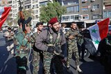 Syrian soldiers wave weapons and national flags as they chant slogans against US President Donald Trump/