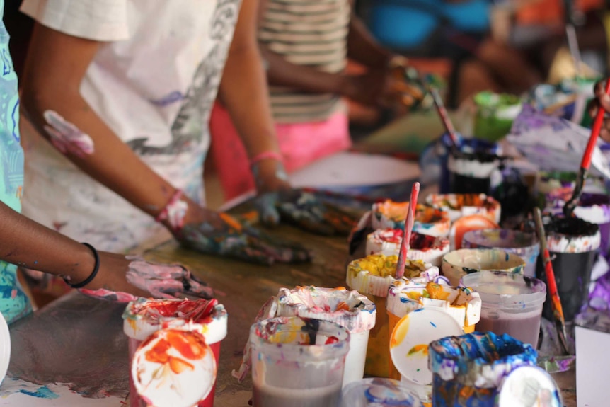 Children's hands with paint splatters.