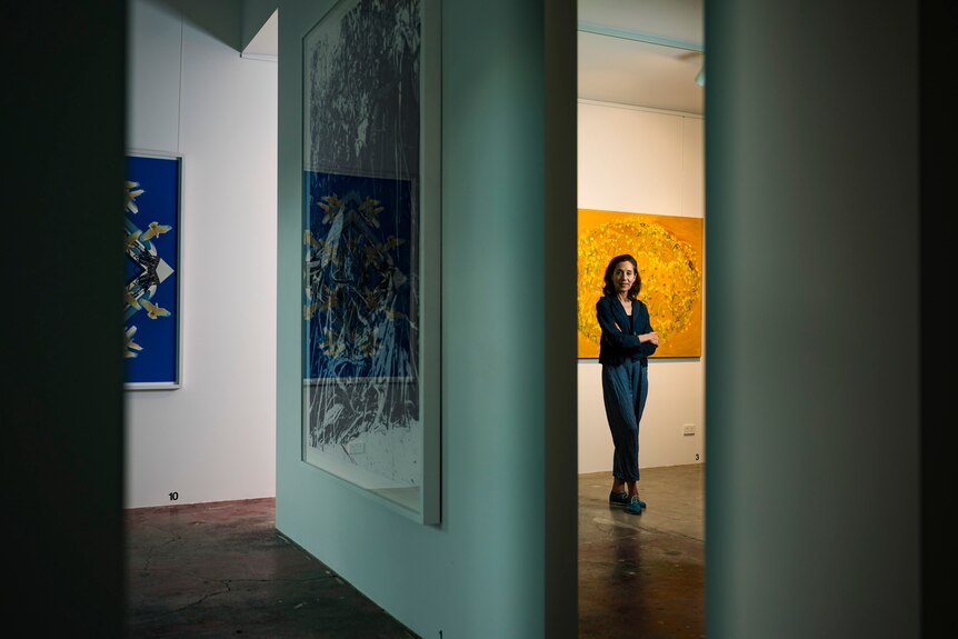 A brunette woman in her early 60s stands in a gallery 
