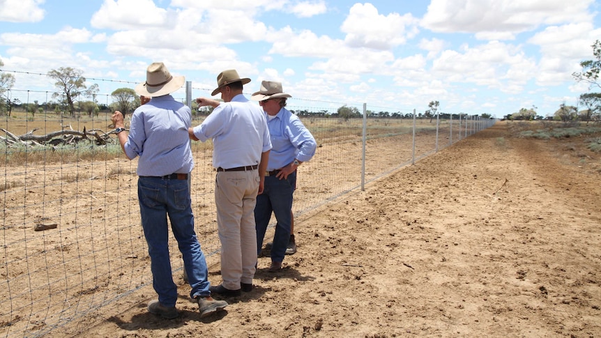 Sandy Williams, Longreach Regional Council Mayor Ed Warren and Wild Dog Fencing Commissioner Vaughan Johnson inspect the fence.