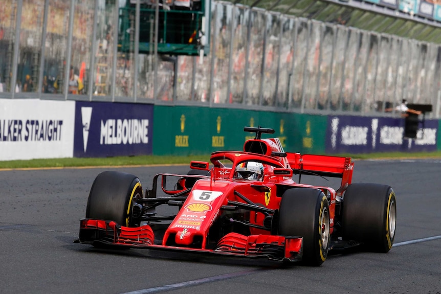 A red Ferarri car on a racetrack.