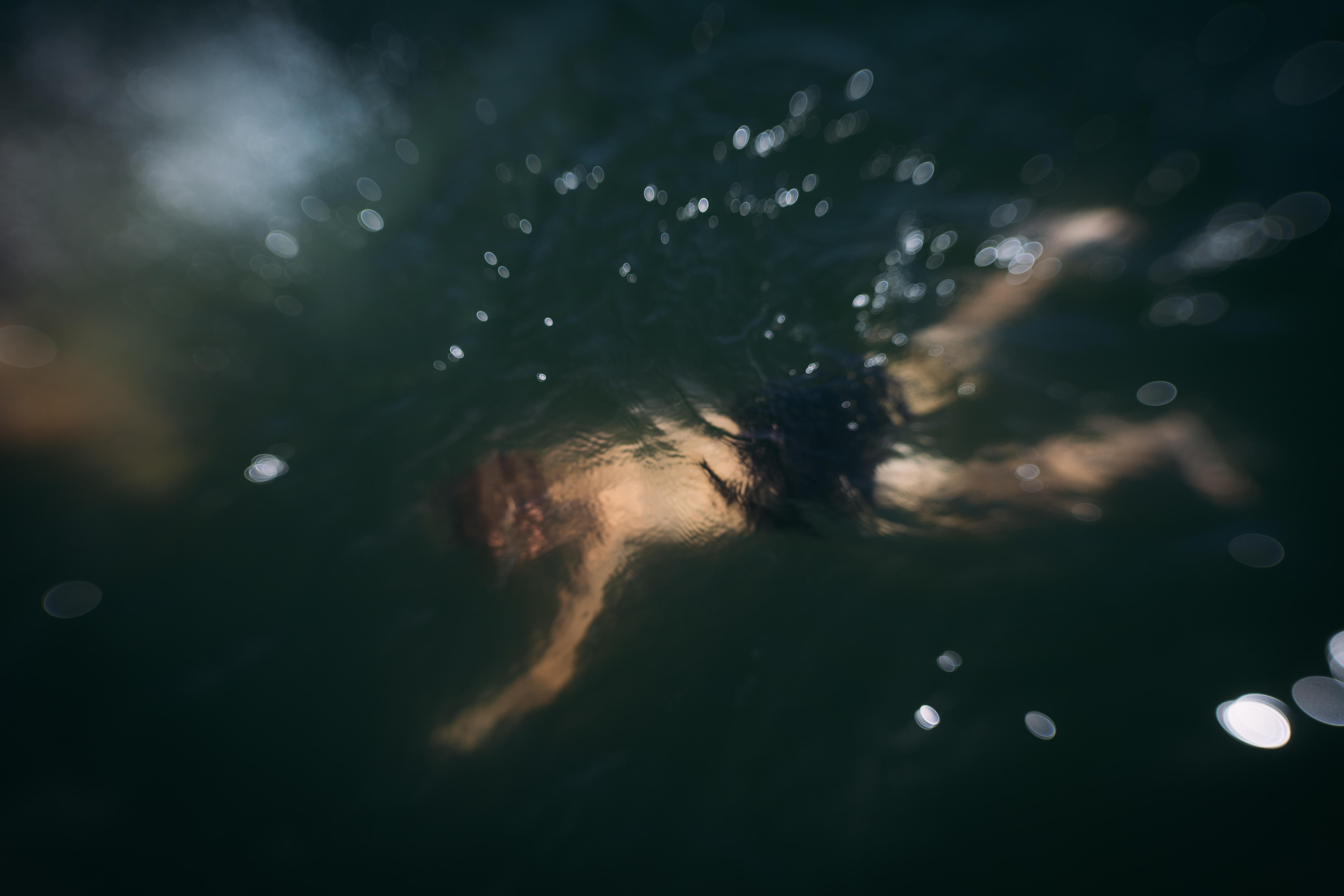 Blurred image of someone swimming underwater.
