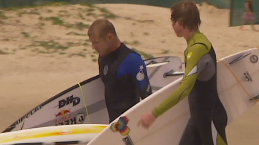 World surfing champion Mick Fanning and Ben Beasley carrying surfboards on the beach at Snapper Rocks