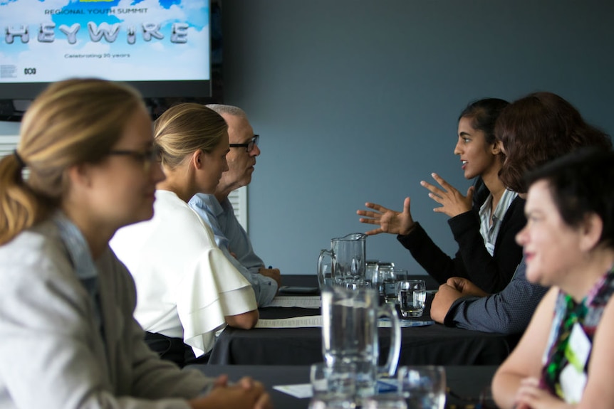 Young people talking across tables to government officials during Heywire summit.