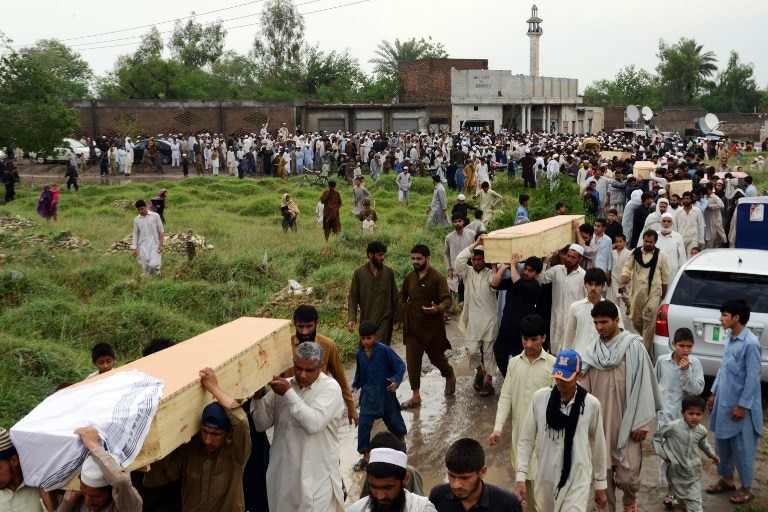 Peshawar residents carry bodies of flood victims