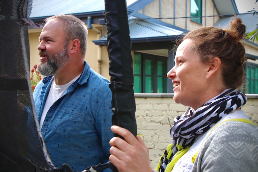 Daniel Boardman and Kate Sindrey watch on as their kids play in the backyard. May 2020.