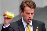 Dan Tehan holds up a stick of butter in federal parliament