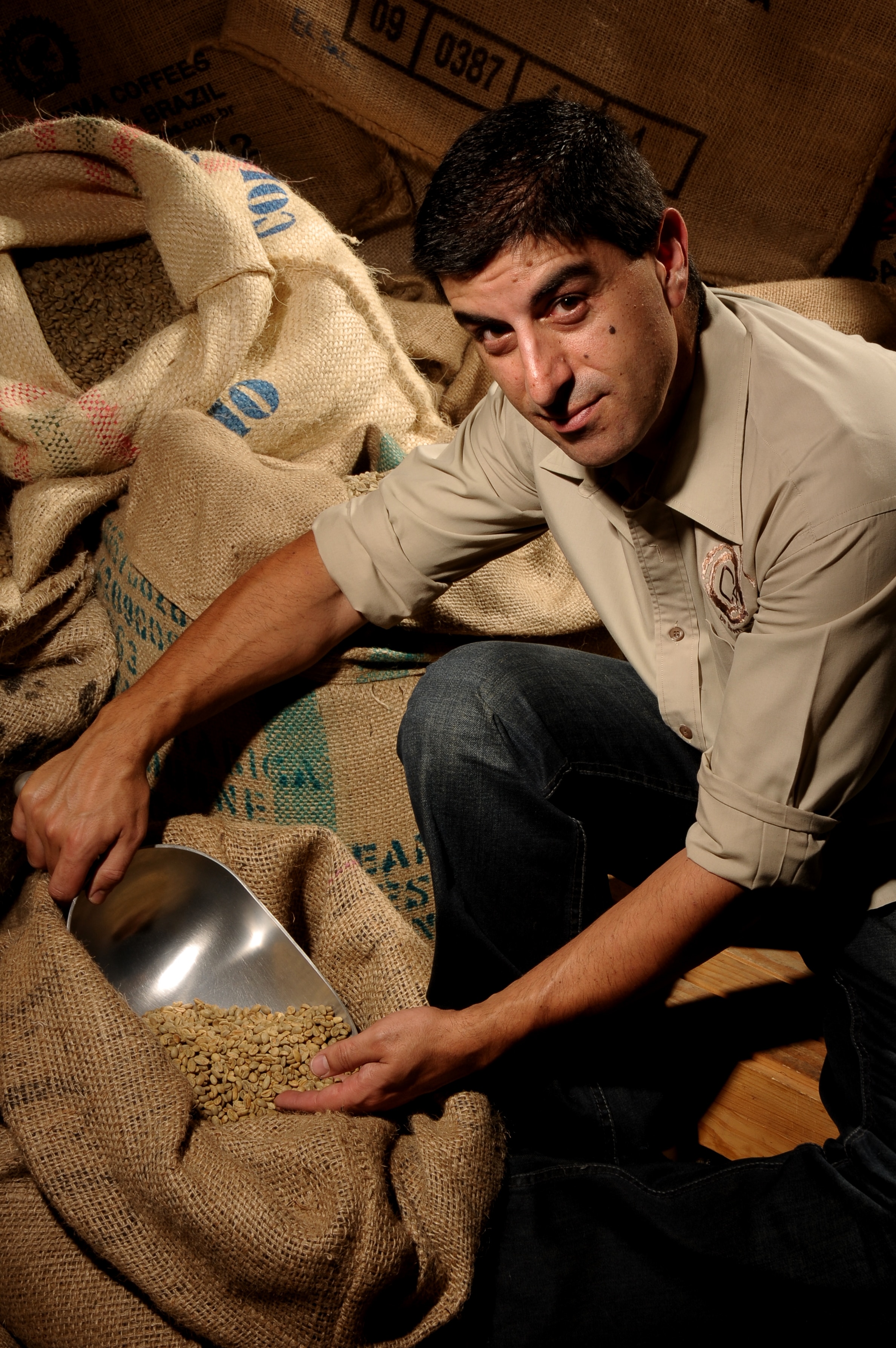Man with short dark hair, looking inside bag of coffee beans