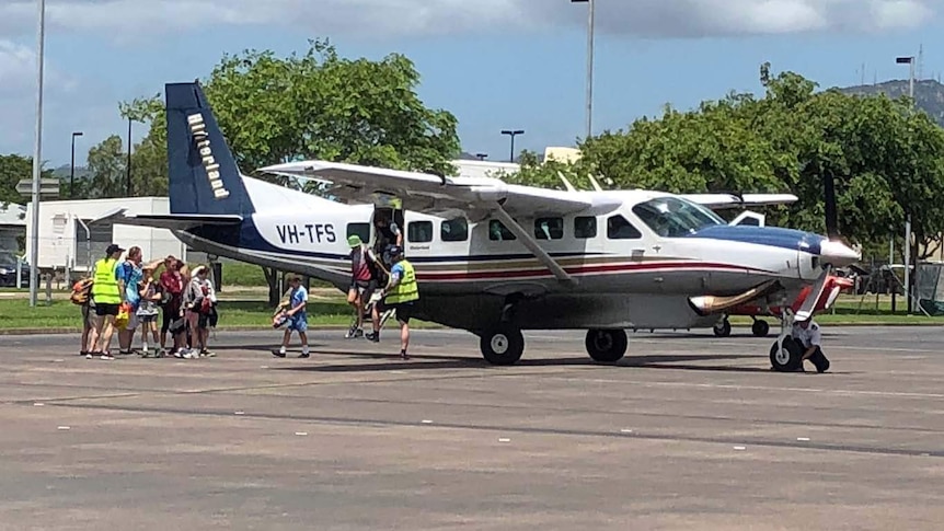 School students get off a fixed-wing aircraft in Townsville.