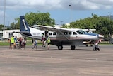 School students get off a fixed-wing aircraft in Townsville.