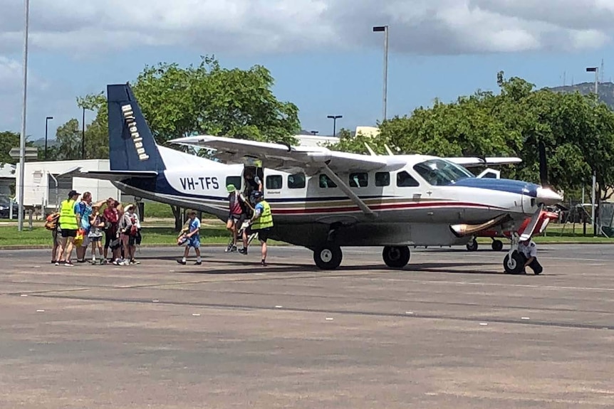 School students get off a fixed-wing aircraft in Townsville.