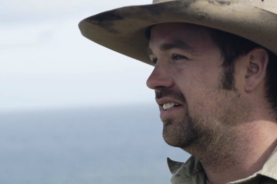 A profile shot of a man's face. He's wearing an Akubra hat or similar