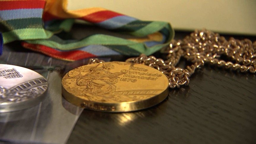 A gold medal from the 1976 Montreal Olympic Games sits next to a silver medal from the 1988 Seoul Games.