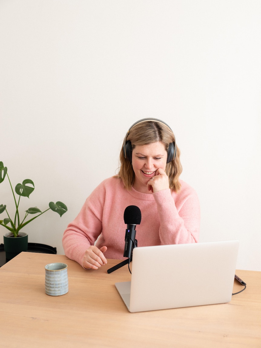 Sophie Walker at a desk with a laptop, talking into a microphone.