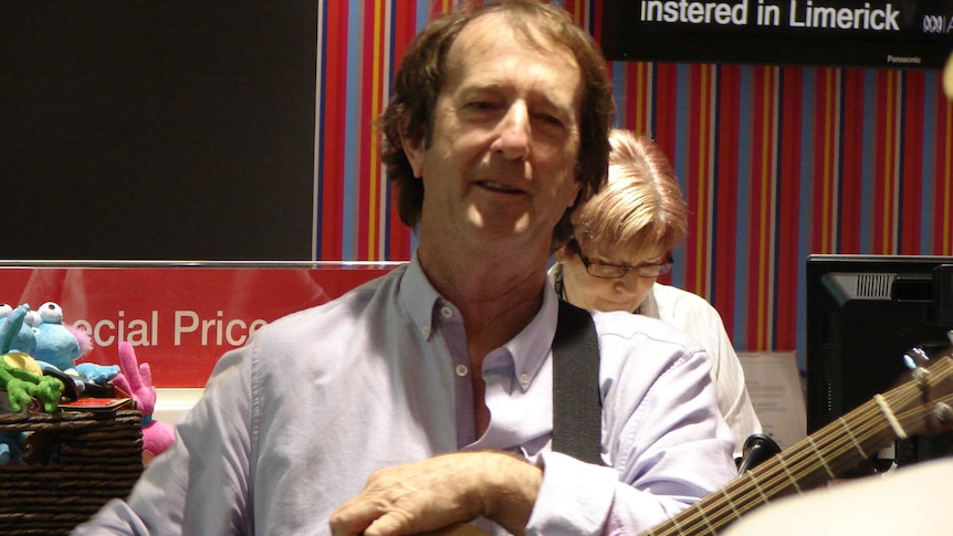 Ian MacNamara in an ABC studio with his guitar