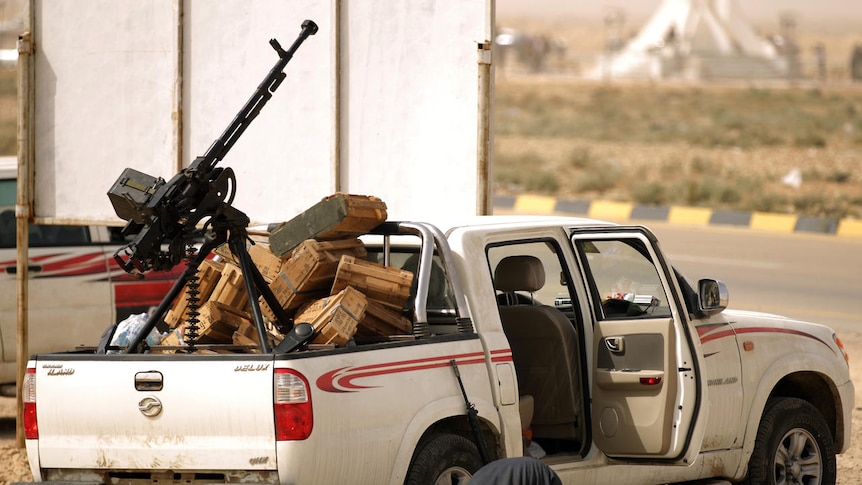Libyan rebel prays next to truck
