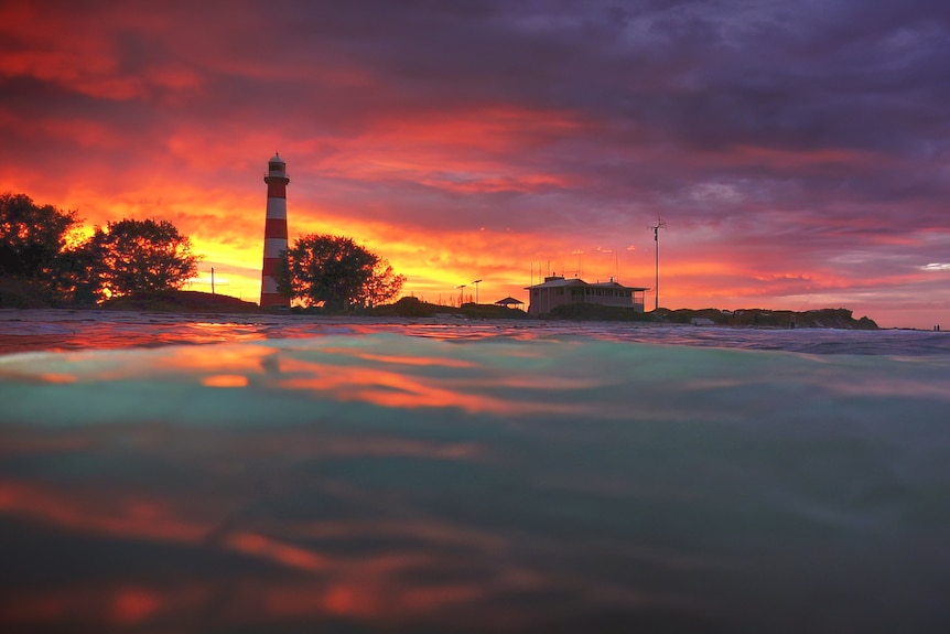 A sunrise shot of the lighthouse from within the sea