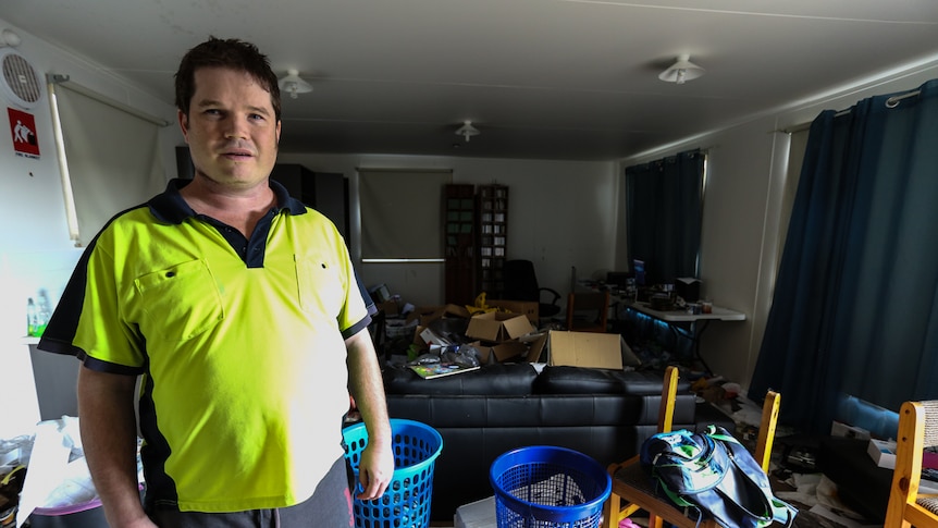 Warwick Allen at home in his loungeroom filled with rubbish.