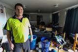 Warwick Allen at home in his loungeroom filled with rubbish.