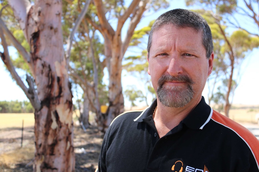 A head and shoulders shot of Gary Sargeant standing in front of trees.