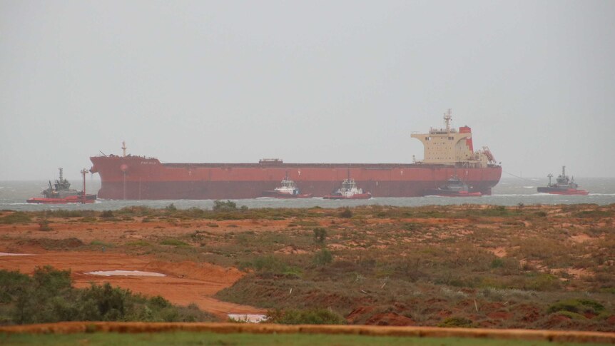 Boats are seen in the water returning to Port Hedland in foggy, overcast conditions.