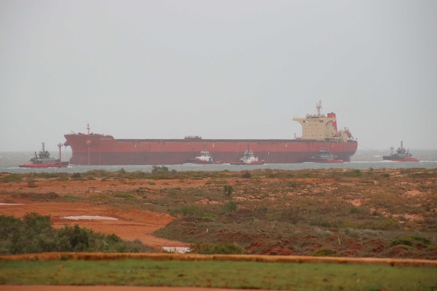 Boats are seen in the water returning to Port Hedland in foggy, overcast conditions.