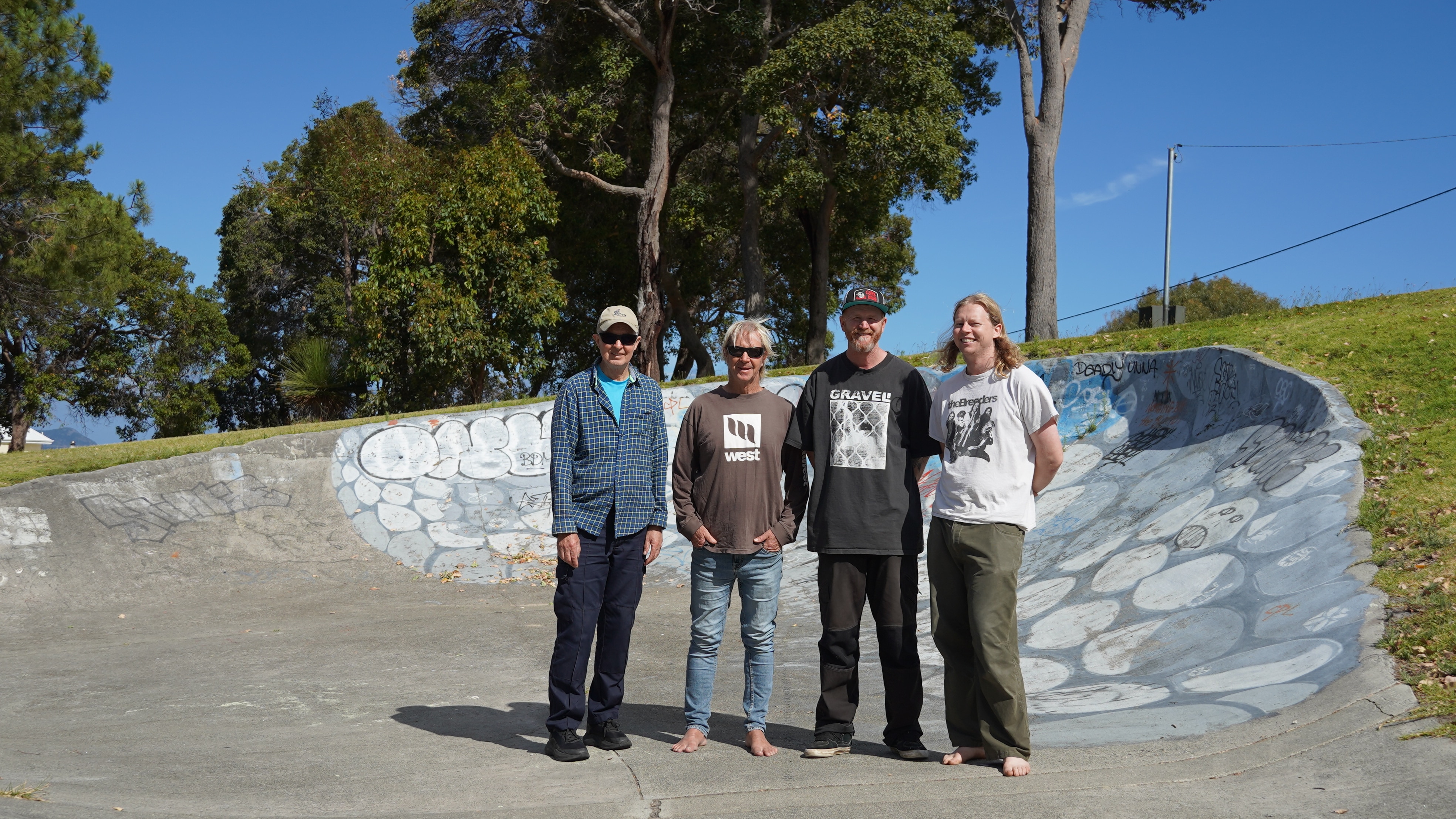 Los cuatro hombres están juntos en un parque de patinaje. 