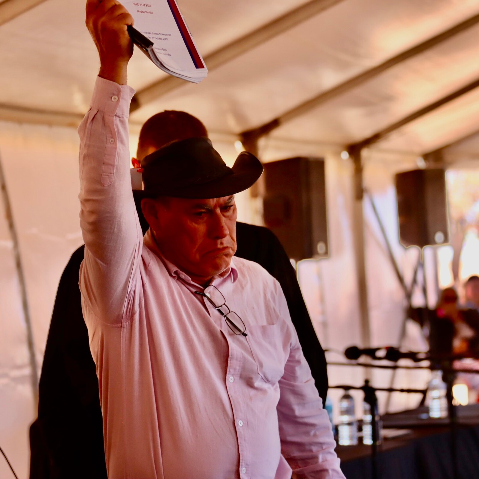 A man looks very determined and holds the legal document above his head